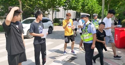 （1）交警同志给学生发放《美丽郑州我的家，平安畅通靠大家》市民学习手册