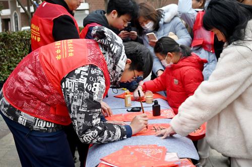 4.学生志愿者认真书写春联内容