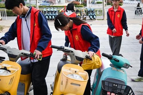 团员在社区内整理电动车排列