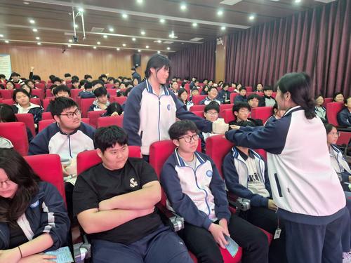 红十字社长为回答问题学生发放文具