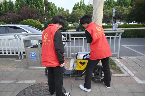 2.学生志愿者们来到校园周边对单车进行规范治理